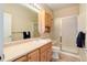 Well-lit bathroom featuring a glass enclosed shower, and vanity with wood cabinets at 9215 W Swarthmore Dr, Littleton, CO 80123