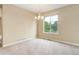 Sunlit dining room with neutral carpeting, modern chandelier, and a large window with outdoor views at 9215 W Swarthmore Dr, Littleton, CO 80123