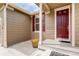 A welcoming front porch features a red door, matching shutters, and decorative flower pot at 9215 W Swarthmore Dr, Littleton, CO 80123