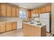 Bright kitchen with wooden cabinets, an island, and white appliances at 9215 W Swarthmore Dr, Littleton, CO 80123