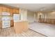 Kitchen with white appliances, wood cabinets, an island, and an open layout to the living area at 9215 W Swarthmore Dr, Littleton, CO 80123