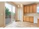 Bright kitchen with sliding glass door to the outdoor deck and wooden cabinets at 9215 W Swarthmore Dr, Littleton, CO 80123