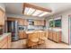 Bright eat-in kitchen features wood cabinets, stainless steel appliances, and a large window bringing in lots of light at 16222 E Prentice Ln, Centennial, CO 80015