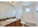 Bright bathroom featuring a shower-tub combo, and single-sink vanity with a large mirror at 4414 Walden St, Denver, CO 80249