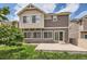 Rear exterior view of a two-story home with sliding glass door leading to patio at 4414 Walden St, Denver, CO 80249