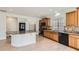 An open kitchen features an island, wood cabinets, granite counters, and stainless appliances at 4414 Walden St, Denver, CO 80249