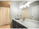 Well-lit bathroom features modern vanity with ample counter space and a shower with a white curtain at 404 Raspberry Ln, Monument, CO 80132
