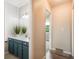 Hallway view of bathroom with shaker cabinets, solid surface counter, mirror, and light fixture at 404 Raspberry Ln, Monument, CO 80132