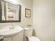 Cozy half bathroom featuring a vanity with a sink, toilet, and decorative framed wall art at 404 Raspberry Ln, Monument, CO 80132
