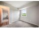 Sunlit bedroom with neutral paint, plush carpeting, a view to the outdoors, and doorway at 404 Raspberry Ln, Monument, CO 80132