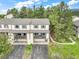 Aerial view of townhomes featuring attached garages, balconies, and beautiful green landscaping at 404 Raspberry Ln, Monument, CO 80132
