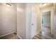 Neutral hallway leading to other rooms featuring light colored walls, wood-look floors, and a white door at 404 Raspberry Ln, Monument, CO 80132