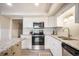 Bright kitchen featuring stainless appliances, granite counters, white cabinets, and modern fixtures at 404 Raspberry Ln, Monument, CO 80132