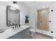 Modern bathroom with a glass-enclosed shower and sleek blue vanity with black hardware at 5815 Peppy San Cir, Sedalia, CO 80135