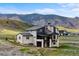 Modern home with a combination of stone and siding, nestled against a scenic mountain backdrop at 5815 Peppy San Cir, Sedalia, CO 80135