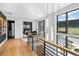 Open hallway with wood floors, modern railing, and scenic views from large windows at 5815 Peppy San Cir, Sedalia, CO 80135