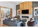 Modern living room with fireplace, wood paneling, plush seating, and staircase access at 5815 Peppy San Cir, Sedalia, CO 80135
