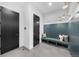 Inviting mudroom with black doors, a charming blue bench, and stylish wall lighting at 5815 Peppy San Cir, Sedalia, CO 80135