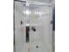 Modern shower with glass doors, tiled walls, and built-in shelving for toiletries at 12856 King St, Broomfield, CO 80020
