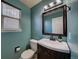 Updated powder room with dark vanity and teal walls at 4443 E Bennington Ave, Castle Rock, CO 80104