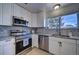 Modern kitchen with white cabinets, granite counters, and stainless steel appliances at 4443 E Bennington Ave, Castle Rock, CO 80104