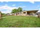 Wide shot of the backyard, featuring a well-maintained lawn and covered parking area at 6627 Eaton St, Arvada, CO 80003