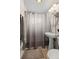Bathroom features a white vanity, neutral walls, and a shower with a gray curtain at 6627 Eaton St, Arvada, CO 80003