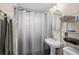 Bathroom features a white vanity, neutral walls, and a shower with a gray curtain at 6627 Eaton St, Arvada, CO 80003
