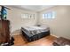 Cozy bedroom with hardwood floors, two windows, and neutral colored walls at 6627 Eaton St, Arvada, CO 80003
