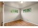 Bedroom features hardwood floors, neutral walls, two windows, and white trim at 6627 Eaton St, Arvada, CO 80003