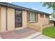 Charming brick home with an enclosed front entrance with storm door and a well maintained front yard at 6627 Eaton St, Arvada, CO 80003