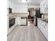 Bright kitchen with white cabinets, gray counters, and light wood-look flooring at 6627 Eaton St, Arvada, CO 80003