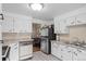 Bright kitchen with white cabinets, gray countertops, and stainless steel refrigerator at 6627 Eaton St, Arvada, CO 80003