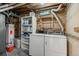 Functional laundry area with washer, dryer, storage shelves, and water heater at 6627 Eaton St, Arvada, CO 80003