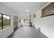 Bright sunroom features large windows, white walls, gray flooring, and a wood-burning stove at 6627 Eaton St, Arvada, CO 80003