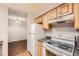 Galley-style kitchen with wood cabinets and modern appliances at 14590 E 2Nd Ave # 304B, Aurora, CO 80011