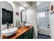 Stylish bathroom with double sinks, wooden vanity, and a tub with a shower at 6111 W Maplewood Pl, Littleton, CO 80123