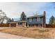 Charming exterior of a home with brick and siding, featuring a well-maintained lawn, mature trees and a paved driveway at 6111 W Maplewood Pl, Littleton, CO 80123