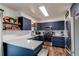 Modern kitchen with white countertops, navy cabinets, stainless steel appliances, and wood-look flooring at 6111 W Maplewood Pl, Littleton, CO 80123