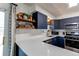 Modern kitchen with white countertops, navy cabinets, stainless steel appliances, and subway tile backsplash at 6111 W Maplewood Pl, Littleton, CO 80123