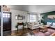 Comfortable living room with a 'welcome' sign, couch, natural light, and wood floors at 6111 W Maplewood Pl, Littleton, CO 80123