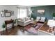 Inviting living room with hardwood floors, accent wall, neutral sofa, and an abundance of natural light at 6111 W Maplewood Pl, Littleton, CO 80123