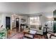 Bright living room featuring hardwood floors, large window, and cozy seating area at 6111 W Maplewood Pl, Littleton, CO 80123