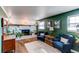 Cozy living room with painted brick fireplace, wood floors, plants and lots of natural light at 6111 W Maplewood Pl, Littleton, CO 80123