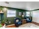 Stylish living room boasts natural light, two cozy blue chairs, and unique decor for a welcoming atmosphere at 6111 W Maplewood Pl, Littleton, CO 80123