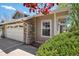 Charming home exterior with stone accents, lush landscaping, and a convenient two-car garage at 6803 W Yale Ave, Lakewood, CO 80227