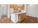 Well-lit kitchen with a center island, ample cabinet space, and wood flooring at 6803 W Yale Ave, Lakewood, CO 80227