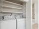 Convenient laundry room with washer, dryer, wire shelves and shower at 6803 W Yale Ave, Lakewood, CO 80227