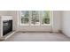 Bright living room featuring large windows, a fireplace, and plush carpeting at 6803 W Yale Ave, Lakewood, CO 80227