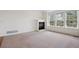 Cozy living room featuring a fireplace, plush carpeting, and plenty of natural light at 6803 W Yale Ave, Lakewood, CO 80227